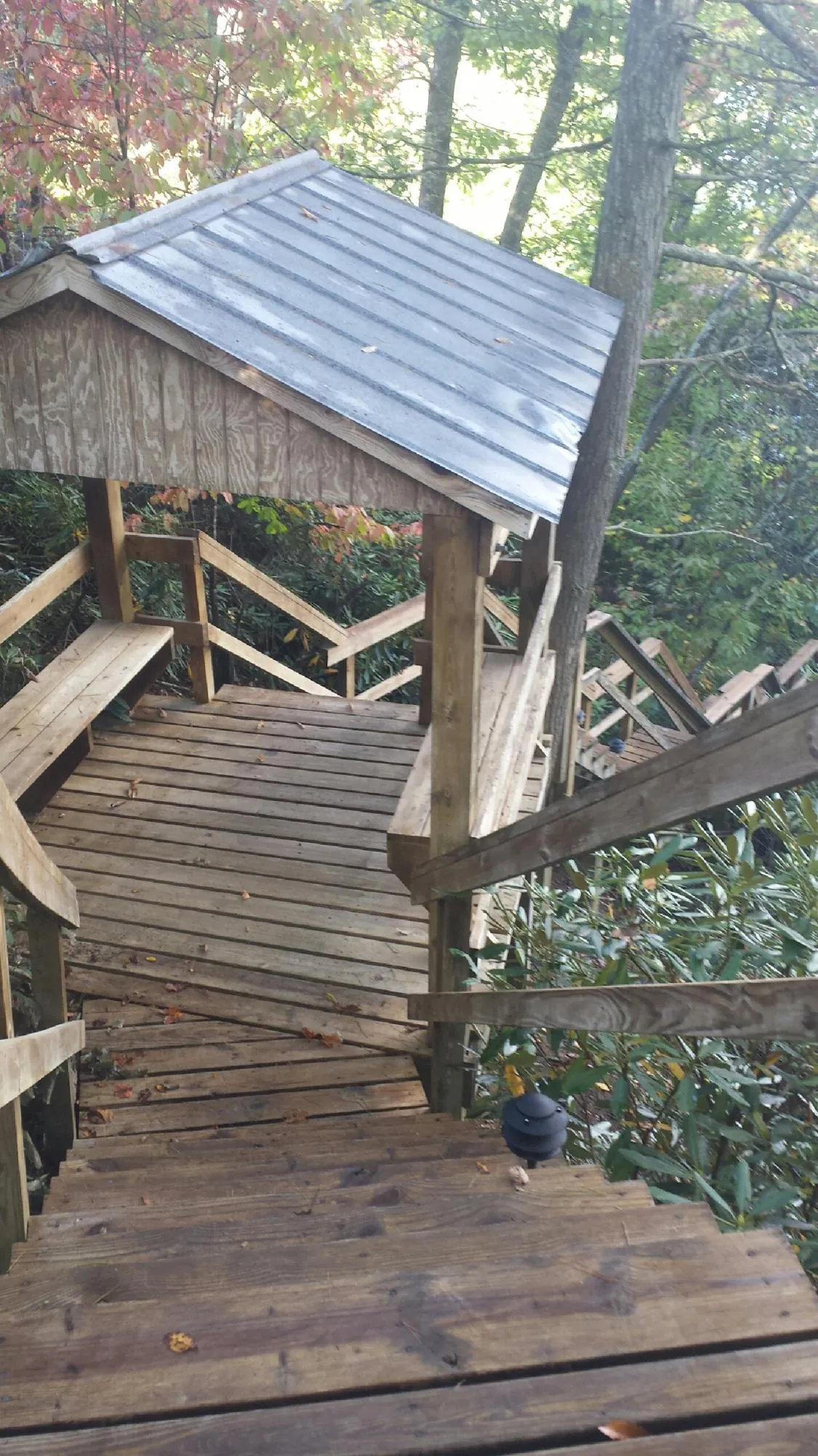 Metal roofed shelter over wooden steps on a wooded walkway — Skylight Repair & Installation work by our crew in South Bend